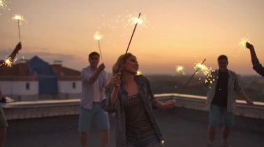 Genç bayan arkadaşlarıyla dans ediyor.