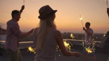 Şapkalı genç kadınlar partide dans ediyor.