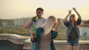 Çatıda dans eden sarışın kadın.