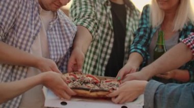 Altı genç Rus 'tan oluşan bir şirket sıcak pizzanın tadını çıkarıyor.