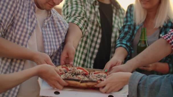 Společnost šesti mladých ruských lidí, kteří si užívají horkou pizzu — Stock video