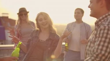 Dancing girl rooftop party slow motion group of multiracial friends hanging out young asian woman dancing enjoying roof top event at sunset drinking alcohol having fun on weekend celebration.