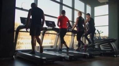 Spor salonundaki koşu bandında koşan sağlıklı insanlar. Konsept dışı. İnsanlar spor salonunda koşu bandında kardiyo eğitimi alıyorlar..