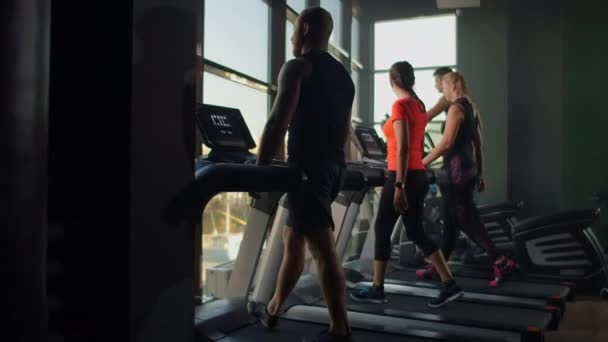 Gruppe von Menschen im Fitnessstudio trainiert in Zeitlupe auf Laufbändern — Stockvideo