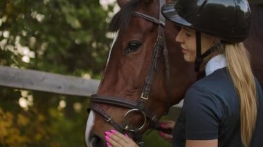 Dişi, antrenmandan önce bir atla eğleniyor.