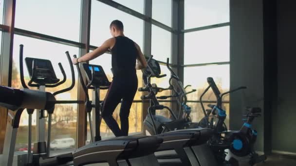 Portré fitness férfi bemelegít edzés előtt elliptikus kereszt edző tornaterem klubban. Közelkép férfi edzés kardio testmozgás cross tréner fitness. — Stock videók