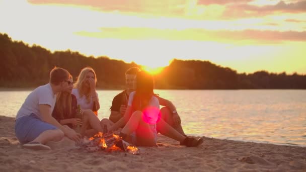 Amigos están disfrutando de la cálida noche de verano en la playa — Vídeo de stock
