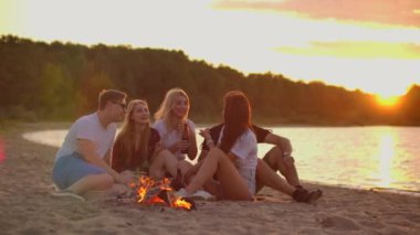 Öğrenciler sahilde sıcak bir yaz akşamının tadını çıkarıyorlar.