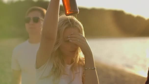 Ein blondes Mädchen auf der Open-Air-Party mit Bier und Freunden — Stockvideo