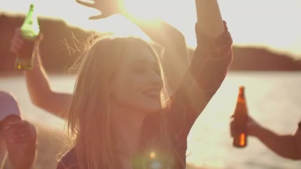 Una giovane donna sta ballando sulla spiaggia festa con birra e amici — Video Stock