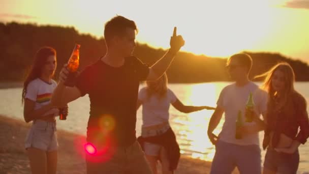 Mladý chlapec tancuje při západu slunce na pláži — Stock video