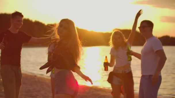 Młoda kobieta tańczy o zachodzie słońca na plaży. — Wideo stockowe