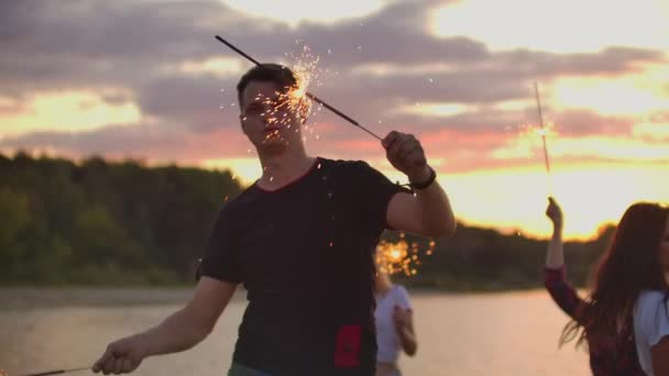 Fiesta teamia con luces de bengala en la playa al atardecer — Vídeos de Stock