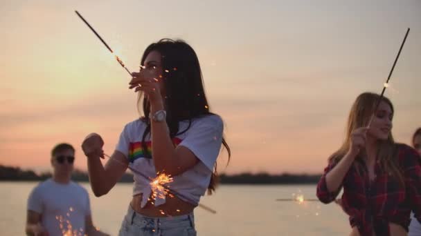 La gente de cámara lenta usa luces de Bengala al atardecer — Vídeo de stock