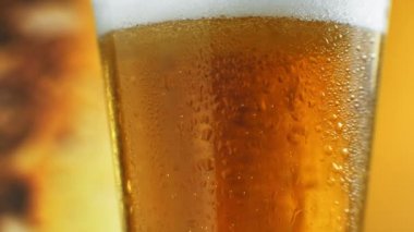 Barmen bardağa soğuk bira dolduruyor. Yakın plan, festival içeceği, soğuk içecek. Stok görüntüleri