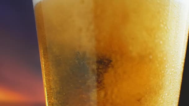 慢动作的巨冰啤酒倒入有汗水的杯子中。 啤酒泡沫浮出水面 — 图库视频影像
