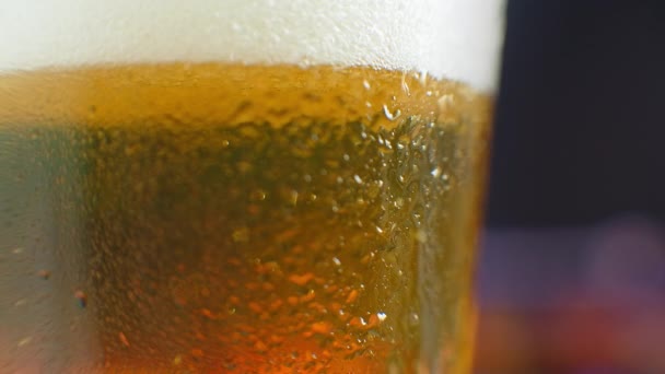 冷たいビールとビールのガラスのマクロショット,泡がガラスの中に上昇.スローモーションビール泡. — ストック動画