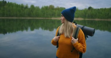 Ormandaki ünlü turist gölünün kıyısındaki Kafkas kadın gezgin. Sonbahar ve yaz aylarında ormanda seyahat ve macera kavramı. Kadın bir orman gölünün haçlarına bakıyor.