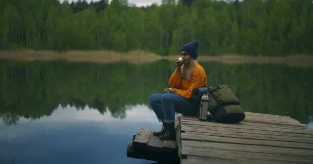 Retrato de uma jovem viajante no lago em câmera lenta. Olhe para a beleza do lago da floresta — Vídeo de Stock