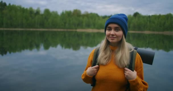 Retrato de uma jovem viajante no lago em câmera lenta. Olhe para a beleza do lago da floresta — Vídeo de Stock