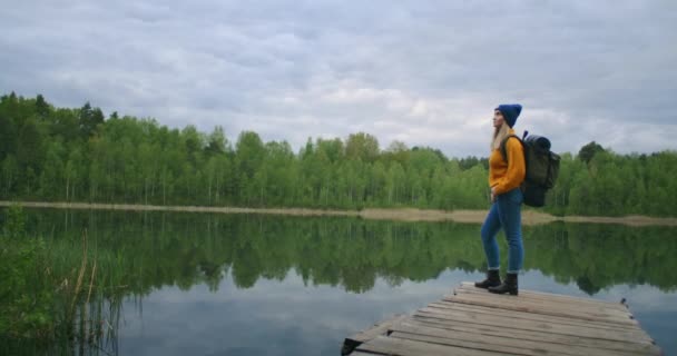 Retrato de uma jovem viajante no lago em câmera lenta. Olhe para a beleza do lago da floresta — Vídeo de Stock