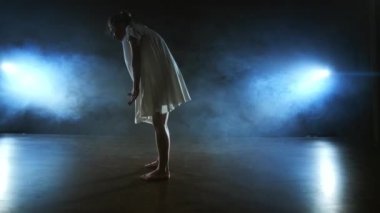 Ağır çekim: Duman içinde kadın dansçı. Modern bale sahnesinde yalınayak