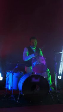 Harika grunge rock müzisyeni sahnede davul çalıyor, harika bir metal solo yapıyor, neon ve mavi ışıklar tarafından aydınlatılıyor..