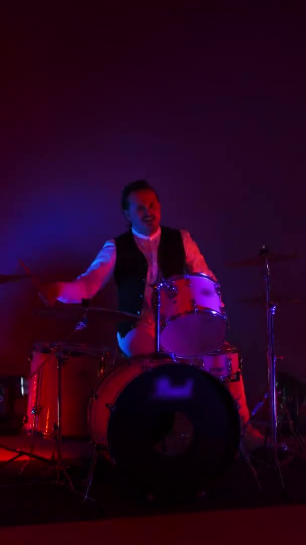 Video vertical luz de neón brillante un baterista masculino toca en un estudio con luz de neón y humo — Vídeos de Stock