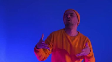 Mavi arka planda elleri izole bir şekilde dans eden adam. Parti, müzik, yaşam tarzı, radyo ve disko konsepti