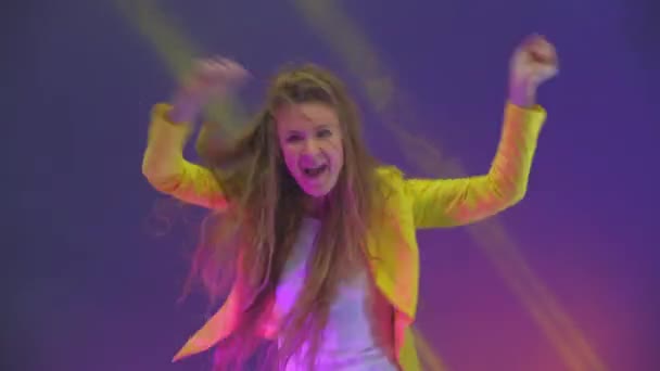 Divertida mujer inusual con el pelo largo divirtiéndose, sonriendo, bailando en el estudio sobre fondo azul. Música, concepto de danza — Vídeos de Stock