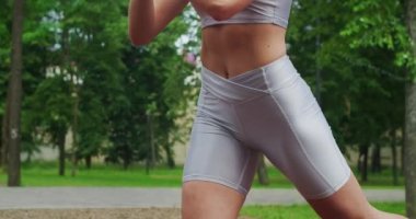 Atletizm trenleri parkta bir bankta, bir gencin üzerine çömeliyor.