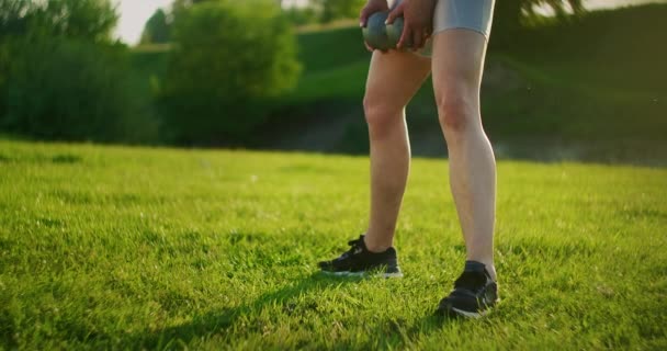 Nahaufnahme eines hockenden Frauenbeines in einem Park auf Gras mit Hanteln — Stockvideo