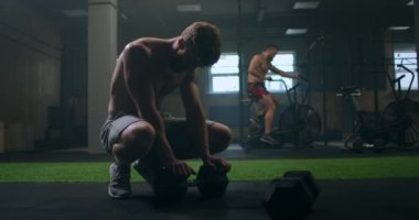 Spor salonundaki yorgun bir adam egzersiz yaptıktan sonra dinleniyor. Eğitimden sonra ara ver..