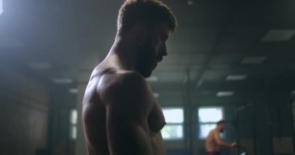 Fokuserade män i gymmet gör sig redo att börja träna. en professionell idrottsman utför övningar i gymmet. fokus och syfte — Stockvideo