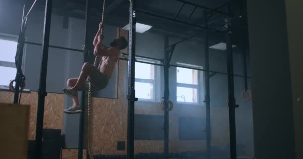 The man climbs up the rope and reaches the top. the concept of success through hard work — Stock Video