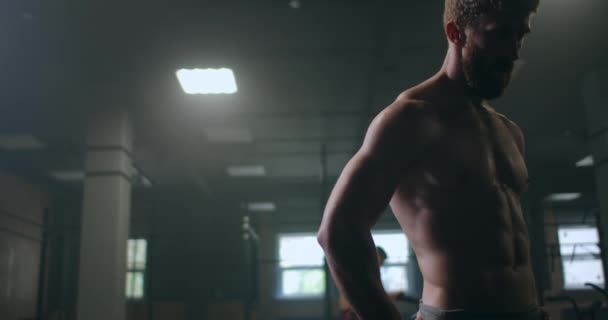 Atletický muž bez trička ztěžka dýchá a před cvičením se soustředí. vaření a morální nastavení — Stock video