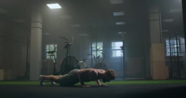 Spor salonunda şınav çeken bir adam. Şınav ve egzersizden sonra nefes alıp vermek. Spor ve spor için mükemmel. Genç sporcu spor salonunda şınav çekiyor. Sporcu Fitnes 'le meşgul.