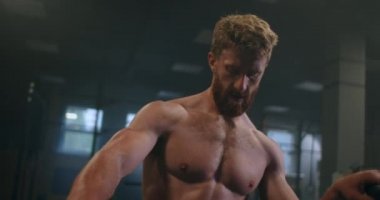 Dinlenme zamanı. Spor kıyafetli genç bir adam spor salonunda pencerenin önünde dururken bitkin görünüyor..