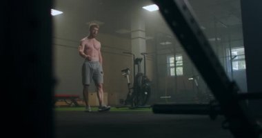 Şimdiden bir sonraki müsabakayı bekliyor. Yorgun kas atleti. Yorgun adam antrenmandan sonra dinleniyor. Spor salonunda elinde su şişesiyle oturan yorgun ve bitkin bir erkek sporcu..