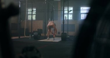Spor salonunda halter kaldırma egzersizi yapan genç adam. Adam spor salonunda kaldırma egzersizi yapıyor. Genç sporcu halteri göğsüne kaldırır. Erkek halterci bir yarışmada halter kaldırıyor.