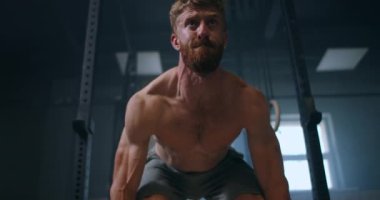 Spor salonunda halter kaldırma egzersizi yapan genç adam. Adam spor salonunda kaldırma egzersizi yapıyor. Genç sporcu halteri göğsüne kaldırır. Erkek halterci bir yarışmada halter kaldırıyor.