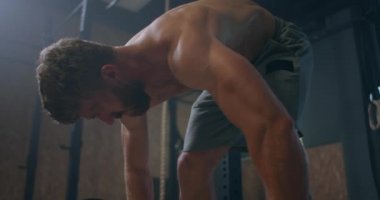 Spor salonunda halter kaldırma egzersizi yapan genç adam. Adam spor salonunda kaldırma egzersizi yapıyor. Genç sporcu halteri göğsüne kaldırır. Erkek halterci bir yarışmada halter kaldırıyor.