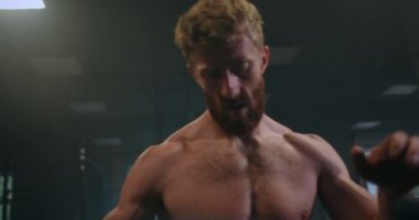 Dinlenme zamanı. Spor kıyafetli genç bir adam spor salonunda pencerenin önünde dururken bitkin görünüyor..