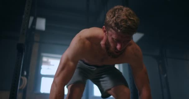 Brett skott av unga kaukasiska extrem tyngdlyftning idrottare man tränar med tung skivstång i stora hardcore gym hall. — Stockvideo