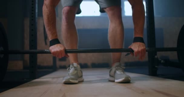 Junger Mann beim sauberen und ruckartigen Gewichtheben in der Turnhalle. Mann beim Kreuzheben im Fitnessstudio. Junger Athlet hebt Langhantel zur Brust. Männlicher Gewichtheber hebt eine Langhantel bei einem Wettkampf — Stockvideo