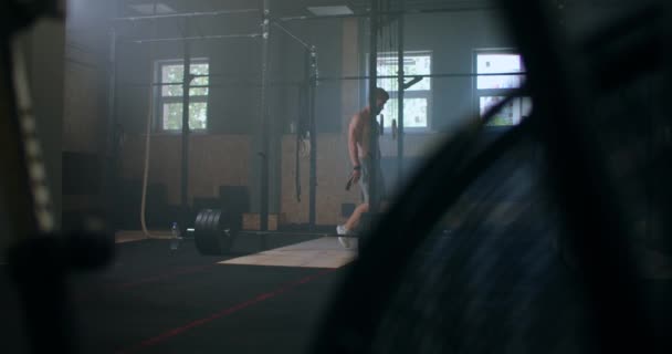 Jeune homme athlétique caucasien changer, mettre des sangles de levage de poids dans le vestiaire de la salle de gym avant l'entraînement au ralenti. attaches bras à haltère avec sangles de fitness. — Video