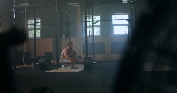Amplio tiro de joven caucásico extrema levantamiento de pesas atleta hombre haciendo ejercicio con pesadas pesas en gran sala de gimnasio hardcore. — Vídeos de Stock