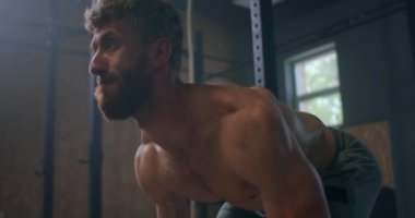 Spor salonunda halter kaldırma egzersizi yapan genç adam. Adam spor salonunda kaldırma egzersizi yapıyor. Genç sporcu halteri göğsüne kaldırır. Erkek halterci bir yarışmada halter kaldırıyor.