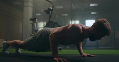 Spor salonunda şınav çeken bir adam. Şınav ve egzersizden sonra nefes alıp vermek. Spor ve spor için mükemmel. Genç sporcu spor salonunda şınav çekiyor. Sporcu Fitnes 'le meşgul.