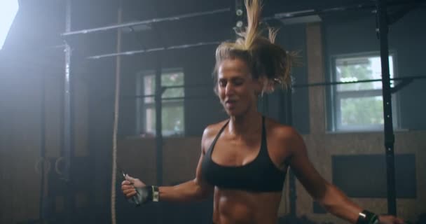 Zeitlupe: Das Frauentraining im Fitnessstudio. Junge Frau beim Seilspringen. Sportlerin springt beim Ausdauertraining im Turnverein auf Springseil. — Stockvideo